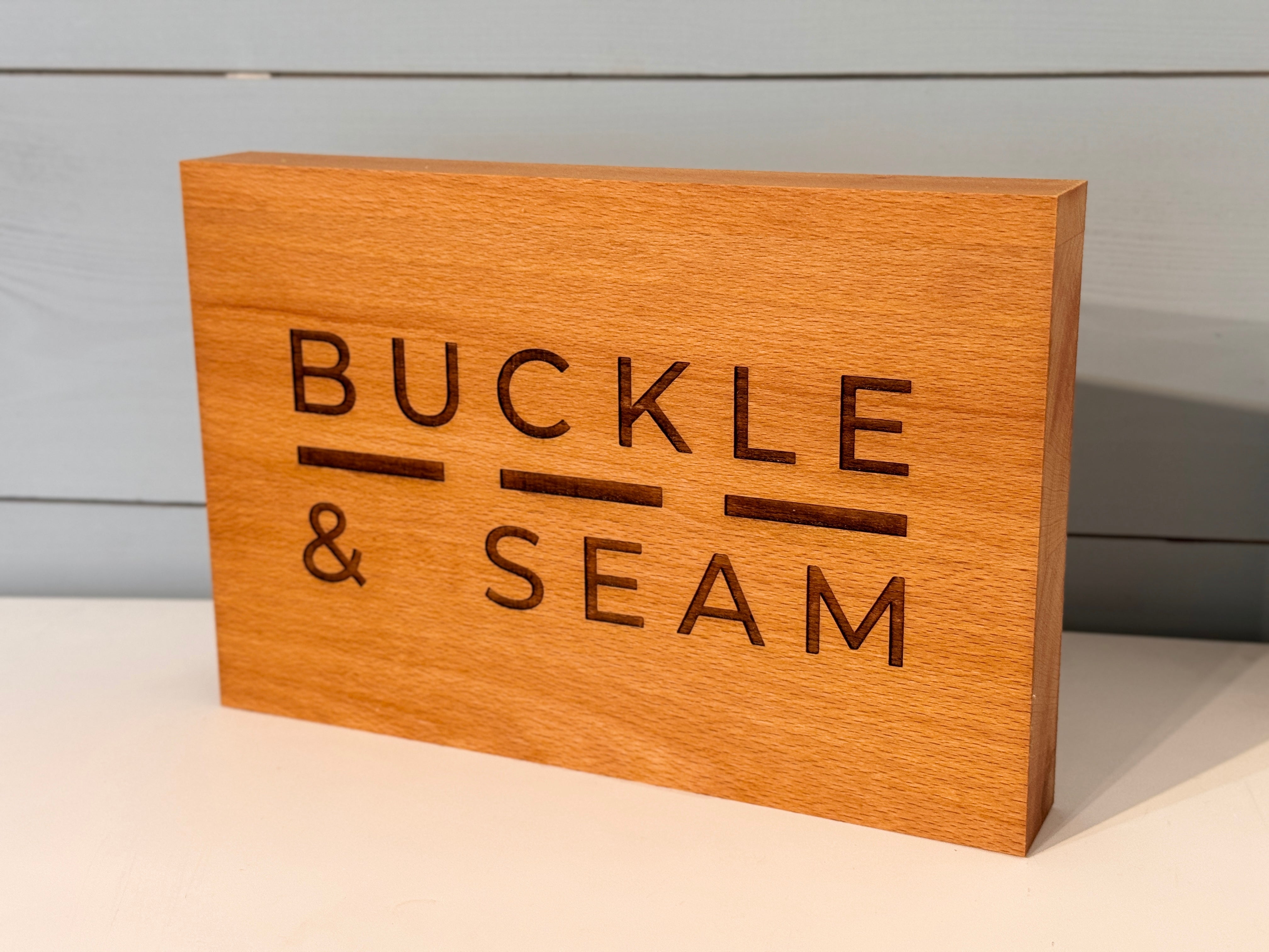 Buckle & Seam Accessories Holzschild Logo Händlerdeko