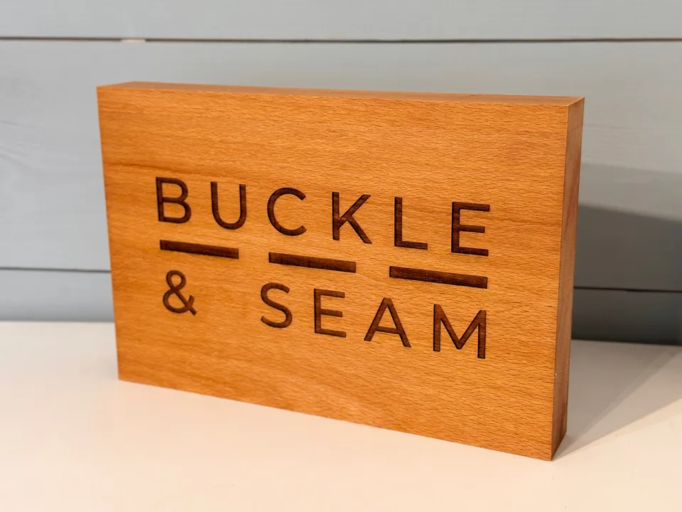 Buckle & Seam Accessories Holzschild Logo Händlerdeko